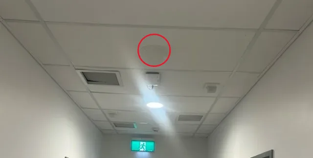 In-building cellular antenna, circled, mounted on a hospital corridor ceiling