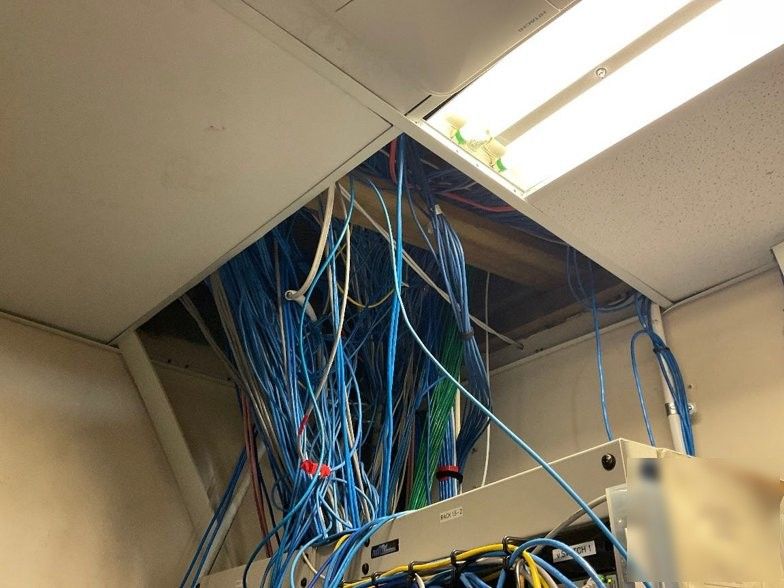 Cabling running through a ceiling cavity above a commercial site, the kind of installed Cat5e infrastructure a Wi-Fi 6 access point now depends on.