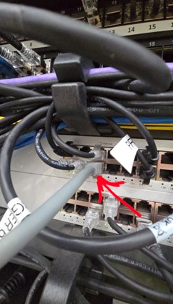 Faulty self-terminated RJ45 at patch panel — red arrow pointing to problem connector