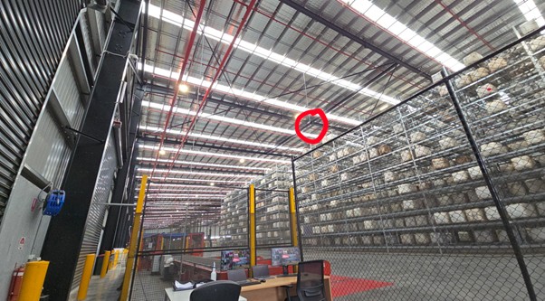 Melbourne warehouse interior — WAP circled in red, suspended high in rafters above gate 5